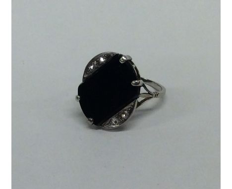 A good Art Deco onyx and diamond ring in white gold claw mount. Approx. 4.7 grams. Est. £100 - £150.