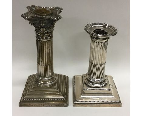 A Corinthian column silver candlestick together with a similar smaller example. Approx. 920 grams. Est. £80 - £120.