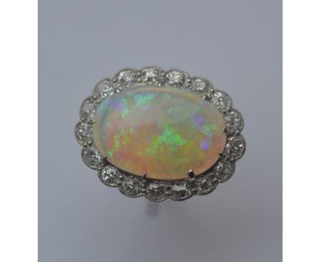 A large opal cluster ring, the central stone being of good colour in attractive platinum claw mount. Approx. 6.3 grams. Est. 