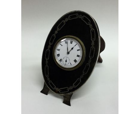A stylish silver and tortoiseshell clock with white enamelled dial. Approx. 302 grams. Est. £50 - £80.