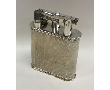 DUNHILL: A massive engine turned desk lighter. Approx. 10 cms high. Approx. 384 grams. Est. £200 - £300.