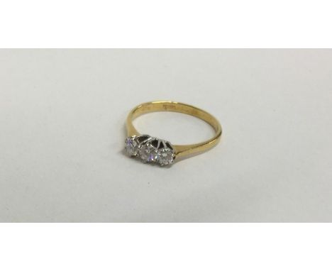 A diamond three stone ring in 18 carat two colour setting. Approx. 2.6 grams. Est. £50 - £80.