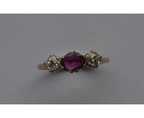 A ruby and diamond three stone ring in claw mount. Approx. 3.7 grams. Est. £150 - £200.