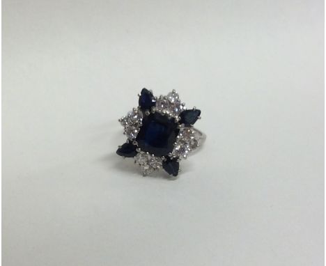 A massive sapphire and diamond cluster ring, the large central cushion shaped sapphire in 18 carat claw mount. Approx. 7.7 gr