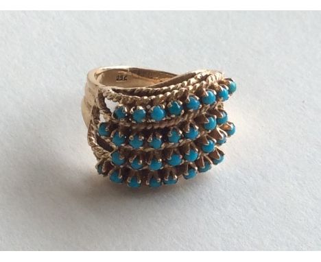 An 18 carat turquoise four row swirl ring with weave decoration. Approx. 8.3 grams. Est. £150 - £200.