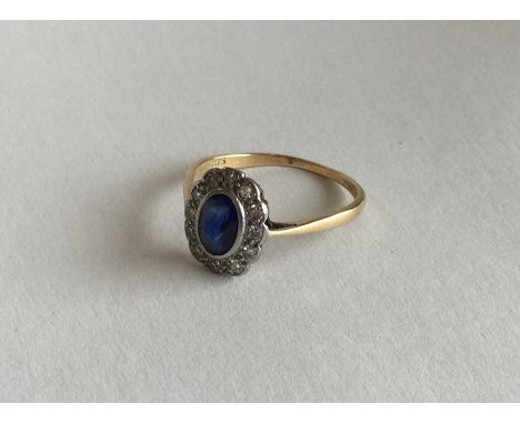 A sapphire and diamond circular cluster ring in two colour gold. Approx. 1.9 grams. Est. £80 - £120.