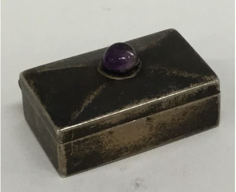 A modern silver hinged top silver pill box with cabochon amethyst. Approx. 13 grams. Est. £20 - £30.