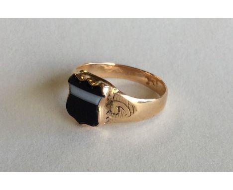 A 9 carat gent's shield shaped signet ring. Approx. 4.2 grams. Est. £35 - £45.