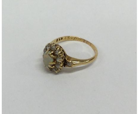 An opal and diamond cluster ring in 18 carat gold. Approx. 3.4 grams. Est. £100 - £150.