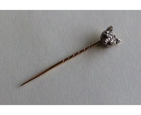 A novelty gold stick pin in the form of a fox's head with rose diamond head and ruby eyes. Approx. 2.7 grams. Est. £60 - £80.