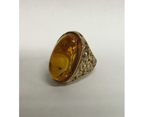 A heavy amber single stone ring with textured 9 carat gold mount. Approx. 16 grams. Est. £100 - £150.