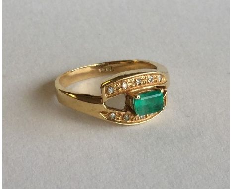 An emerald and diamond eleven stone crossover ring set in gold. Approx. 3.8 grams. Est. £50 - £80.