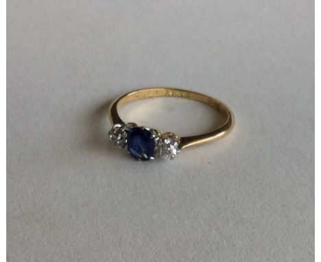 An 18 carat sapphire and diamond three stone ring in claw mount. Approx. 2.1 grams. Est. £70 - £80.