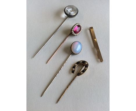 An Antique pearl and red stone stick pin together with a cat's eye horseshoe shaped stick pin together with other stick pins.