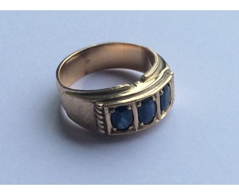 A heavy gent's sapphire three stone ring. Approx. 8.2 grams. Est. £80 - £120.