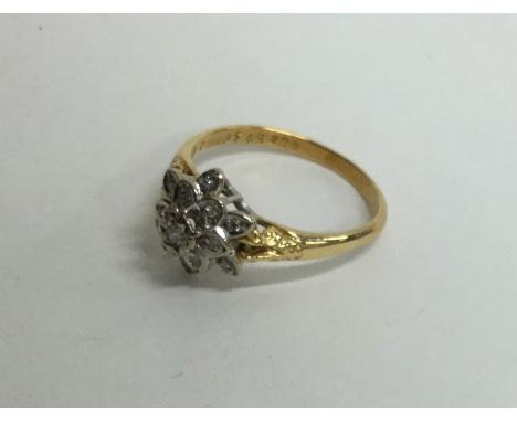 An 18 carat diamond cluster ring in the form of a star. Approx. 3.8 grams. Est. £60 - £80.