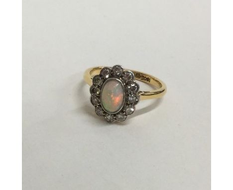 An opal and diamond cluster ring in 18 carat setting. Approx. 4.1 grams. Est. £150 - £200.