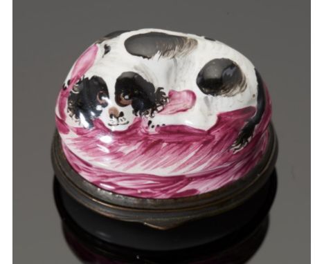A SOUTH STAFFORDSHIRE ENAMEL SPANIEL PATCH BOX, C1780 the black and white painted dog lying on a puce cushion, the sides wais
