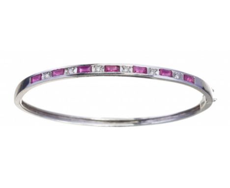 A RUBY AND DIAMOND BANGLE in white gold, 53 x 63mm, foreign control marks including 750, 10g++A few light scratches from norm