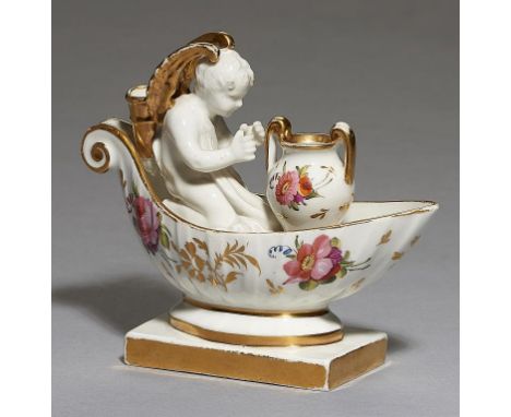 AN ENGLISH PORCELAIN CANOE QUILL HOLDER, POSSIBLY COALPORT, C1820  modelled with a kneeling cherub before a vase and painted 