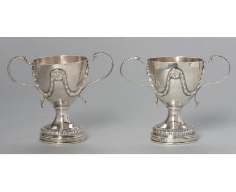 A PAIR OF GEORGE III NEO CLASSICAL STYLE SILVER PRIZE(?) CUPS with applied decoration, festoons and paterae, crested and engr