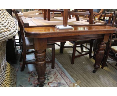 A FIRST 20TH CENTURY OAK FINISHED WINDOUT DINING TABLE on substantial baluster reeded legs, sold together with winder &amp; t