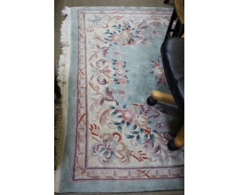 A TURQOUISE GROUND CHINESE WASHWOOL FLOOR RUG with floral decoration 