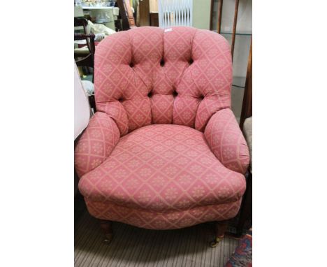 A LATE 20TH CENTURY VICTORIAN DESIGN BUTTON BACKED LOW SEATED ARMCHAIR on show wood legs, with brass capped castors to the fo