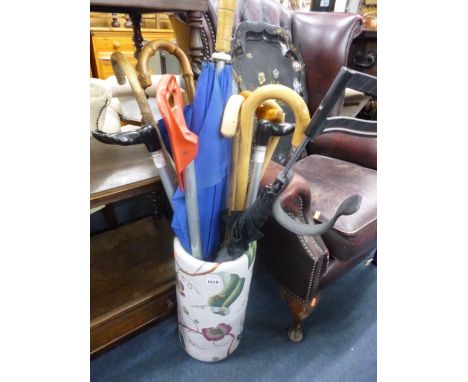 A CERAMIC STICK STAND, and an assortment of sticks, umbrellas etc