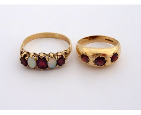 TWO 9CT GOLD GARNET RINGS, the first a gypsy style ring with three circular garnets together with a garnet and opal five ston