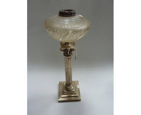 AN OIL LAMP, with glass reservoir on a plated corinthian column support 