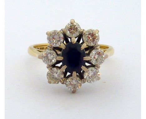 AN 18CT GOLD SAPPHIRE AND DIAMOND RING, the oval shape sapphire within a surround of brilliant-cut diamonds, estimated total 