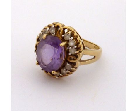 A 9CT GOLD AMETHYST AND CUBIC ZIRCONIA CLUSTER RING, with central oval shape amethyst within a twisted surround and cubic zir