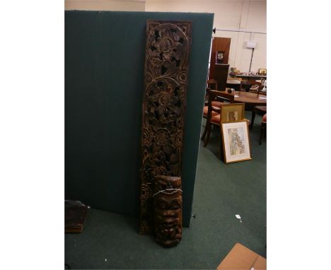 African carving, of a mask with figures, 52cm high, together with a carved foliate panel, 152cm long, (2)