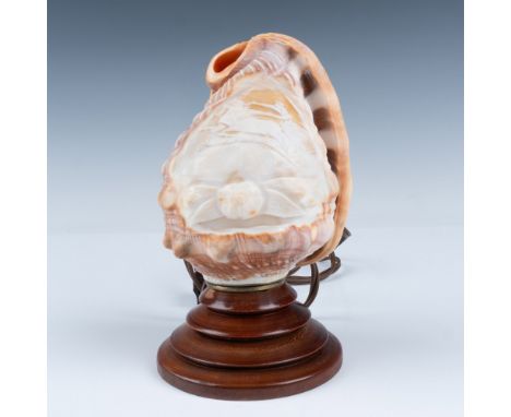 A semi translucent polished shell with a scene depicting one of the Gods racing chariot in the clouds over a mountain. A ligh
