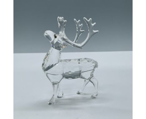 A clear crystal figure of a reindeer with large antlers and his head facing upwards. Melon colored crystal used for the eyes.