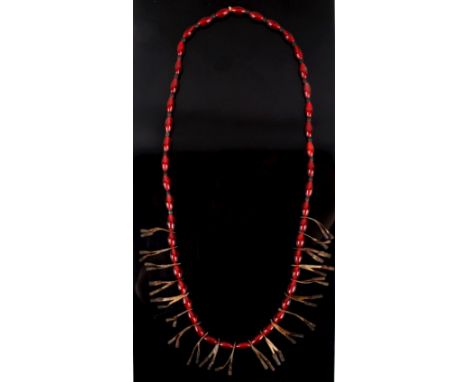 Offered in this lot we have a Plains Indian exotic trade bead necklace with copper jingle cones. The necklace displays red ex