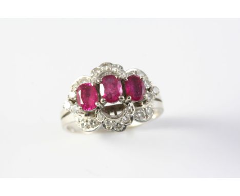 A RUBY AND DIAMOND CLUSTER RING the three oval-shaped rubies are set within a surround of single-cut diamonds, in 18ct white 