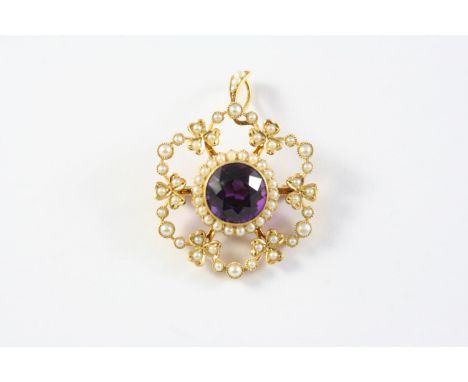 AN EDWARDIAN AMETHYST AND PEARL SET BROOCH PENDANT the 15ct gold openwork foliate mount is centred with a circular-cut amethy
