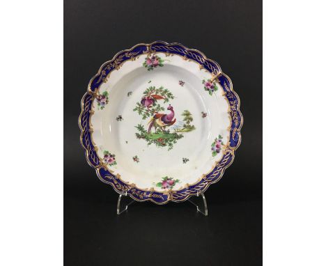 WORCESTER PLATE circa 1765-70, painted with exotic birds inside a blue, gilt and floral border and scalloped rim, open cresce