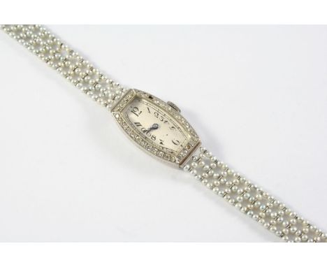 A LADY'S ART DECO DIAMOND AND NATURAL PEARL WRISTWATCH the tonneau-shaped dial with Arabic numerals and single-cut diamonds s