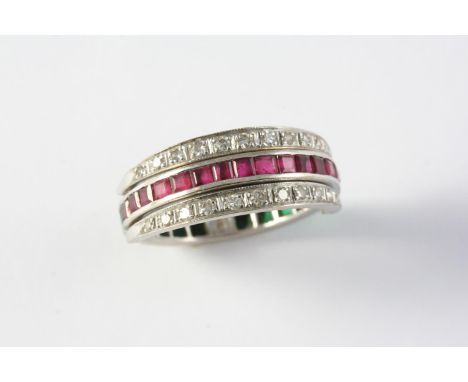 A RUBY, EMERALD AND DIAMOND SWIVEL ETERNITY RING set with circular-cut diamonds and calibre-cut rubies and emeralds, in 18ct 