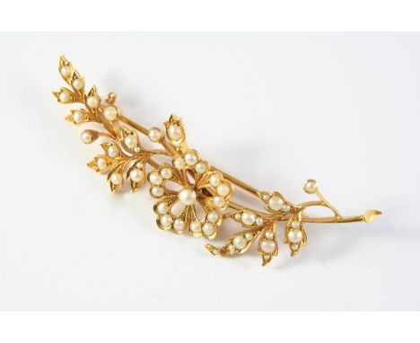 AN EDWARDIAN PEARL AND GOLD FOLIATE SPRAY BROOCH set overall with graduated half pearls, in 18ct gold, 7cm long, 9.4 grams