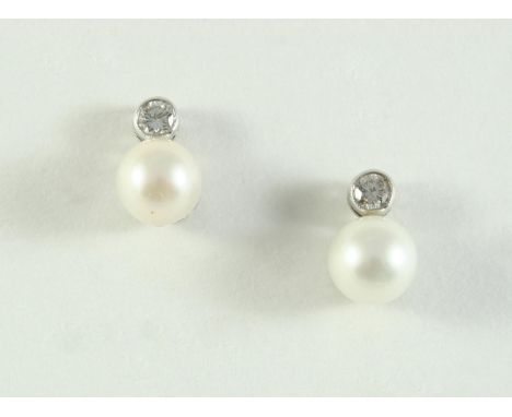 A PAIR OF DIAMOND AND CULTURED PEARL STUD EARRINGS each set with a cultured pearl measuring approximately 7.9mm, suspended fr