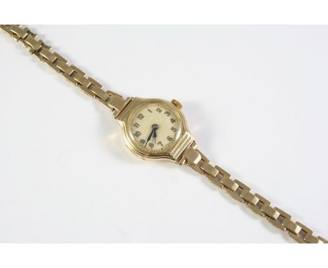A LADY'S 9CT GOLD WRISTWATCH the circular dial with Arabic numerals, numbered to the reverse 23455, on a 9ct gold integrated 