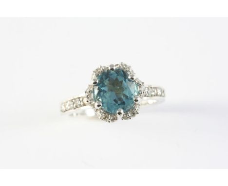 A TOURMALINE AND DIAMOND CLUSTER RING the indicolite tourmaline is set within a surround of circular-cut diamonds, with furth