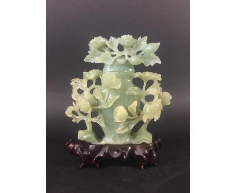 CHINESE GREEN JADE VASE 20th century, carved with flowering foliage, on a hardwood stand, height including stand 23cm (boxed)