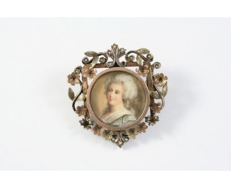 A GEORGIAN MINIATURE PORTRAIT BROOCH depicting the head and shoulders of a woman in a blue dress with white collar, in an orn