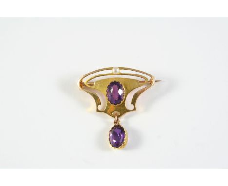 AN ART NOUVEAU AMETHYST AND GOLD BROOCH the gold openwork mount is centred with an oval-shaped amethyst and a small pearl, su