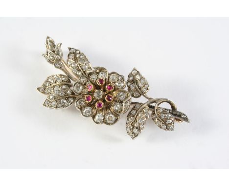 A VICTORIAN DIAMOND AND RUBY FOLIATE SPRAY BROOCH the central flowerhead set en tremblant, the stamens with circular-cut rubi